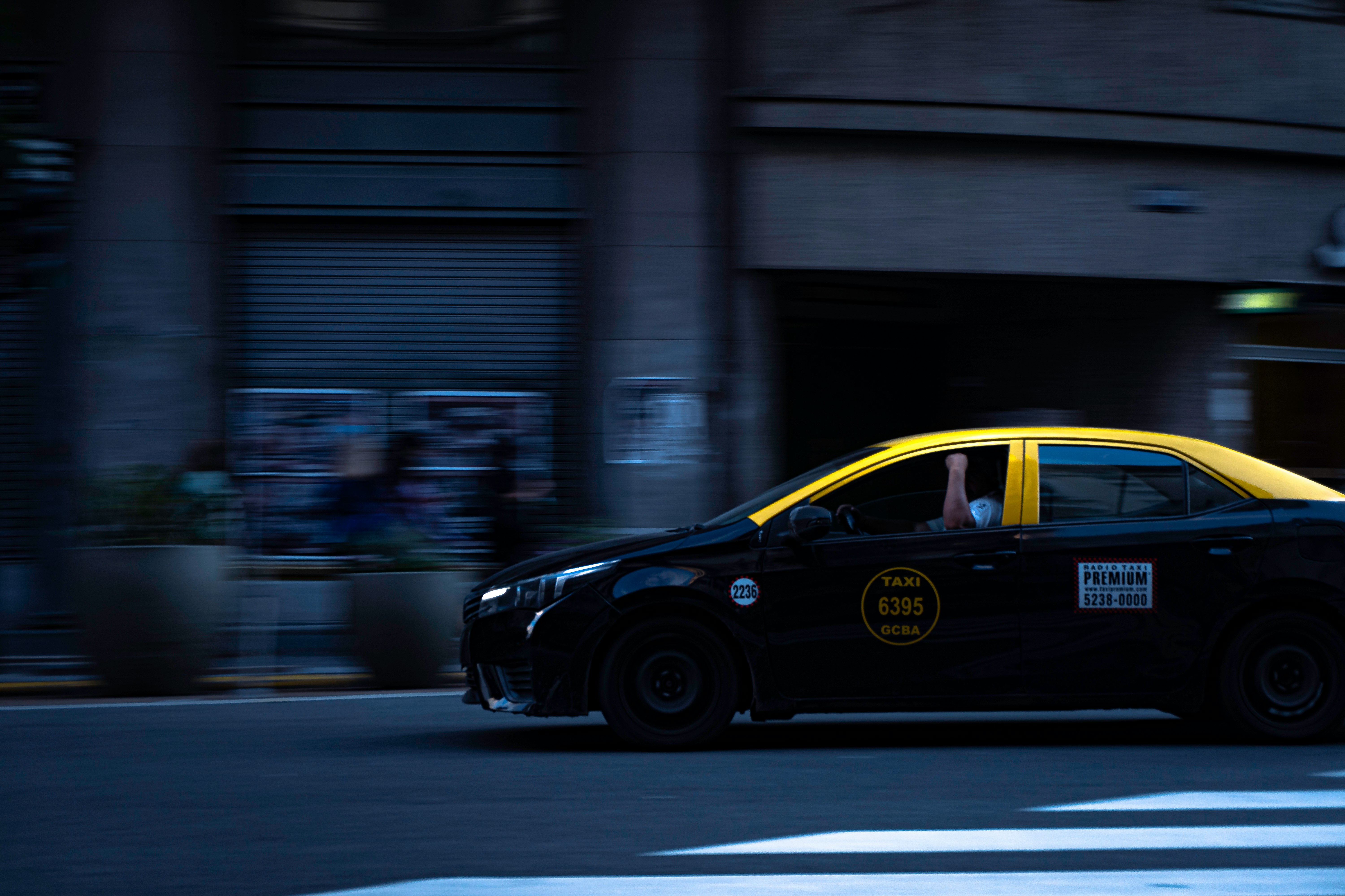 black and yellow sedan on road during daytime